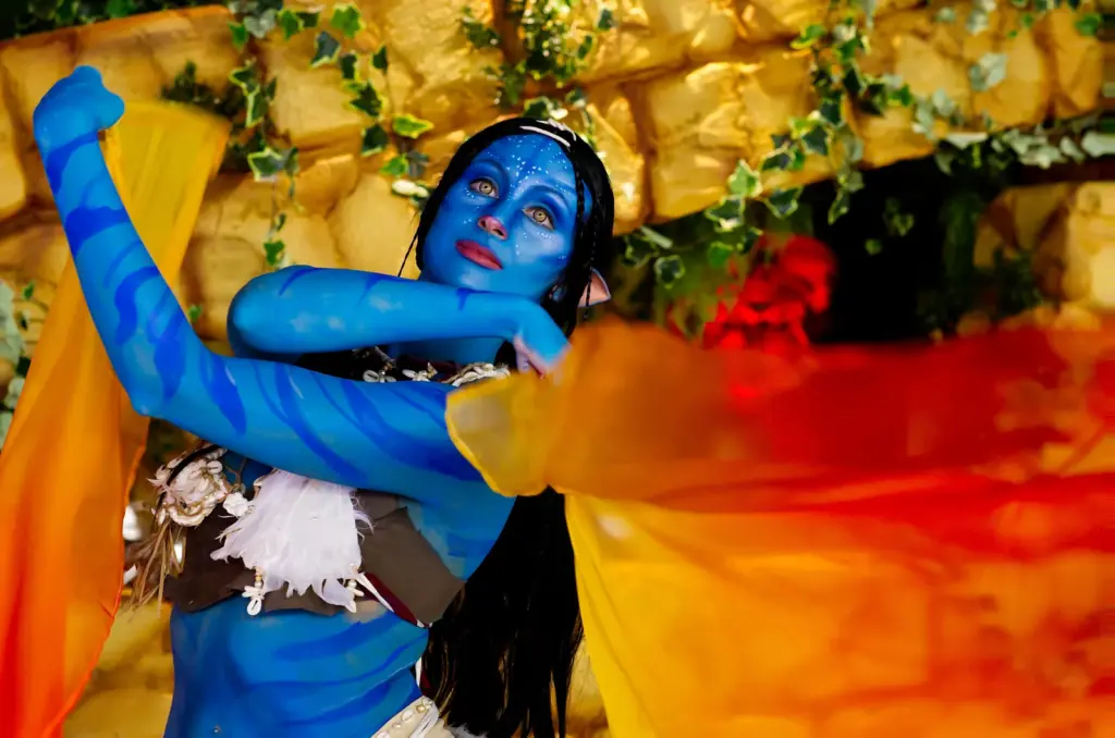 Una performer in costume blu con veli arancioni durante un evento Cinelandia.